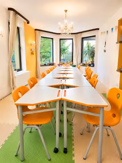 Sala de studiu YoungMinds cu mese modulare și lumină naturală